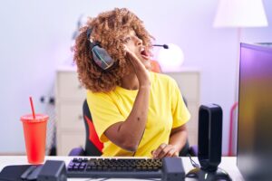 Young woman with headset talking into mic during livestream – example of unusual side gigs like sleep streaming or virtual services